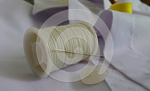 Needle on thread reel and white button