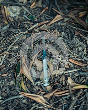 Needles in alley, dirty syringes left in a public place in the city. A used syringe was lying on the ground. The addict threw the