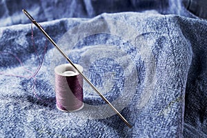 Needles and thread on the background of torn jeans the concept of reasonable consumption of needlework for small businesses