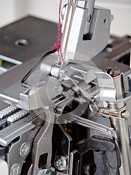 Needles with thread in overstitching machine