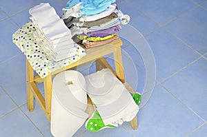 Needs for babies: cloth diapers, nappy liners, changing pad are prepared on wooden stool. photo