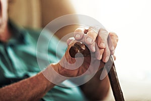 He needs his cane for support. an unrecognizable man leaning on his walking stick.