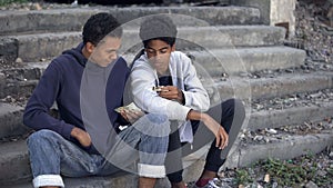 Needy young men counting money sitting stairs, dysfunctional family children photo