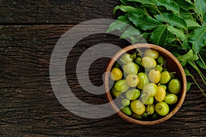 Neem leaf and neem fruit on wooden table.