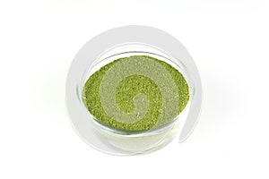 Neem leaf powder in transparent bowl isolated.