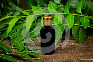 Neem oil in bottle on wooden background.