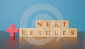 NEET Results a medical Exam conducted at India in wooden block letters on table