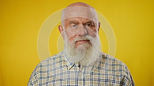Negation. Portrait of an elderly gray bearded man in a shirt, waving his head negatively and raising his crossed arms in