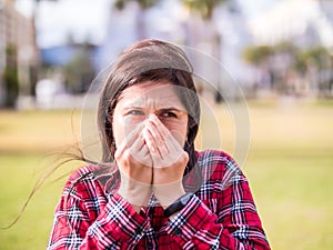 Negative feelings concept - shocked beautiful 20s girl covering her mouth and nose with hands for emotions or bad odor