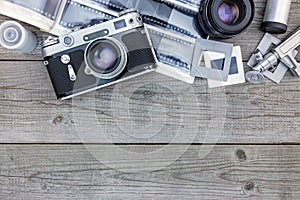 negative films, lenses and retro camera on wooden table background