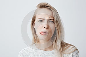 Negative human reaction, feelings and attitude. Close-up portrait of disgusted squeamish blonde woman in casual wear