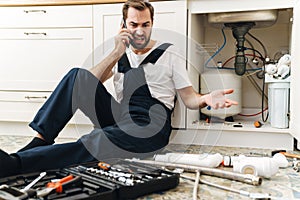 Negative man plumber work in uniform indoors