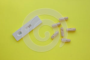 Negative pregnancy test and pills on a yellow background. Motherhood, children, pregnancy, concept of birth control