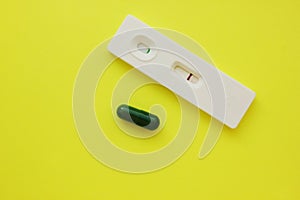 Negative pregnancy test and pills on a yellow background. Motherhood, children, pregnancy, concept of birth control