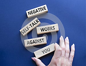 Negative self-talk works against you symbol. Concept words Negative self-talk works against you on wooden blocks. Beautiful deep