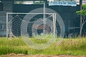 Neglected empty soccer football net on field , unused, dilapidated , Old goal