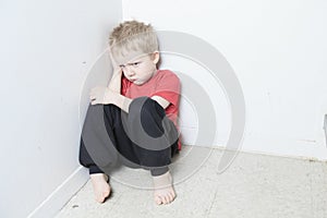 Neglected lonely child leaning at the wall