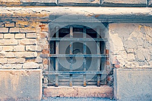 Neglected shabby brick wall with cellar window