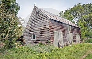 Neglected wooden barn with a corrugated tin roof