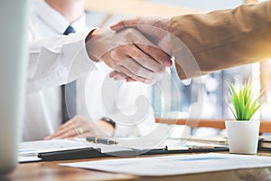 Negotiating business, Two confident business man shaking hands with partners together after finishing up a meeting succeeded