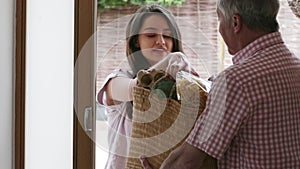 Neighbor Helping Senior Woman With Shopping