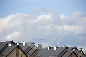 Row house roofs, condo rooftop panorama and bright summer clouds, panoramic roofscape sunny summer cloudscape photo