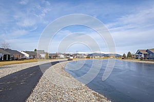 A neighborhood subdivision of homes in a golf course community adjacent to a fairway and water feature pond in Post Falls, Idaho