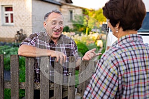 neighbors man and woman chatting near the fence in the village