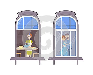 Neighbors in windows of old house. House building facade with open windows and with people.