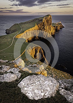 Neist Point, famous landmark with lighthouse on Isle of Skye, Scotland lit by setting sun