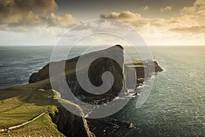 Neist Point and the lighthouse on Isle of Skye at sunset with beautiful colourful clouds in background - Scotland, UK