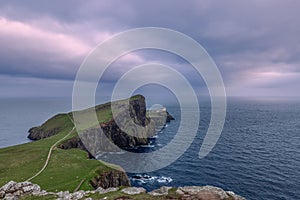 The Neist Point Lighthouse stands sentinel on the cliff edge, a guiding light against the moody skies of Skye