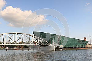 Nemo and steel pedestrian bridge over a canal in Amsterdam.