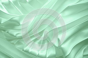 Neo mint color soft satin folded fabric background texture. Close up of ripples on silk fabric. Neo mint color 2020 year concept.