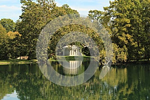 Neoclassical white monument reflecting on lake