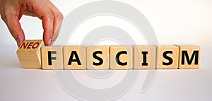 Neofascism symbol. Man hand turns a cube and changes the word fascism to neofascism. Business and fascism or neofascism concept.