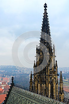 Neogothic stone tower of famous St. Vitus Cathedral on background of city, Prague, Czech Republic