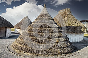 Neolithic straw cone-shaped houses on display near Stonehenge in England