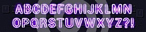 Neon alphabet glowing purple lamp sign on a black electric wall