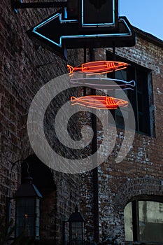 Neon arrow and fish signs directing hungry diners