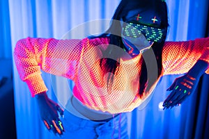 Neon  asian woman dancing. Fashion model woman in neon light, portrait of beautiful model with fluorescent make-up, Art and future