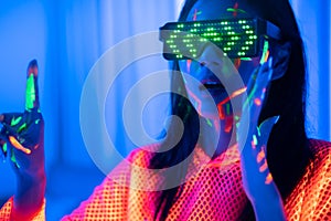 Neon  asian woman dancing. Fashion model woman in neon light, portrait of beautiful model with fluorescent make-up, Art and future