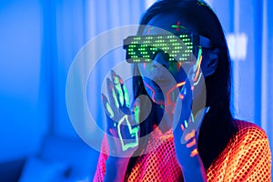 Neon  asian woman dancing. Fashion model woman in neon light, portrait of beautiful model with fluorescent make-up, Art and future