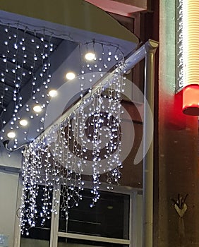 neon blue illumination on the glass facade of the building in the dark during the holiday, a garland of LED strip