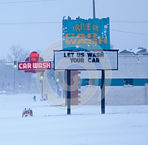 Neon car wash sign in snow storm.