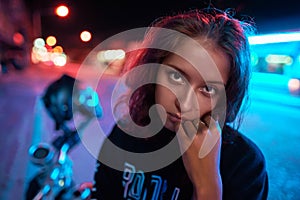 Neon close up portrait of young woman wear hoodie. night city street shot