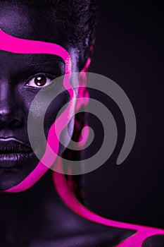 Neon colors. Pink and black body paint. Woman with face art. Young girl with colorful bodypaint. An amazing afro