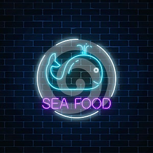 Neon glowing sign of sea food with blue whale in circle frame. Fastfood light billboard symbol.