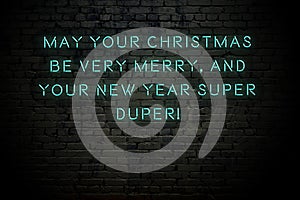 Neon inscription of christmas and new year greetings on brick wall photo