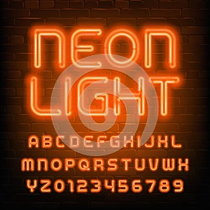 Neon Light alphabet font. Simple orange neon letters and numbers. Brick wall background.